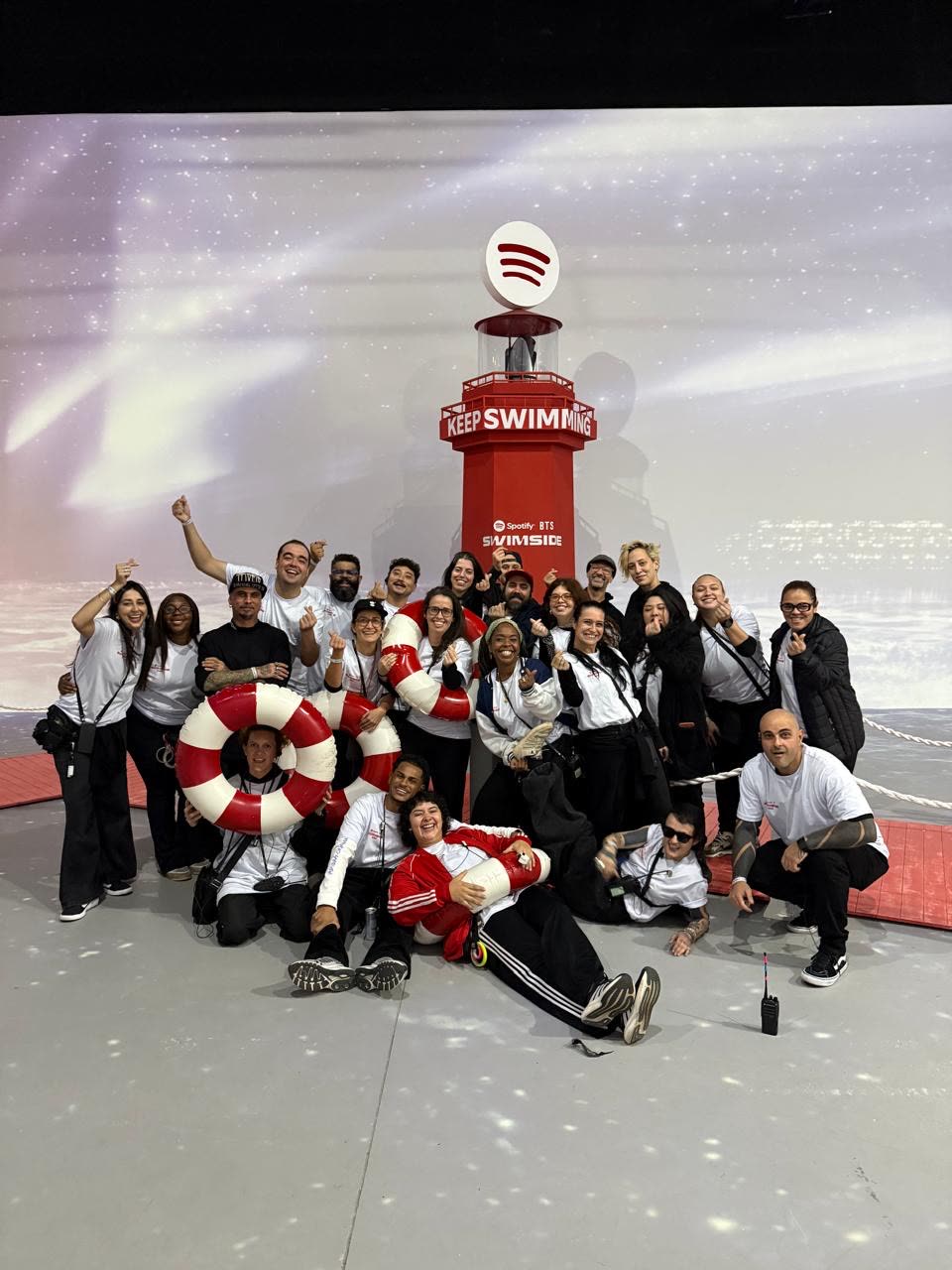 Equipe de produção do Spotify BTS Swimside em frente ao farol Keep Swimming